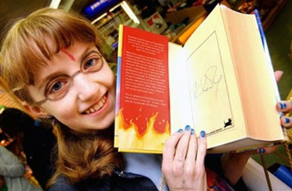 Evanna Lynch adolescente segura sua cópia autografada de Harry Potter e a Ordem da Fênix